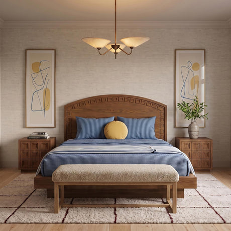 A mid-century bedroom features a patina brass chandelier with textured linen shades centered above a carved wooden bed dressed in blue bedding and framed abstract art.