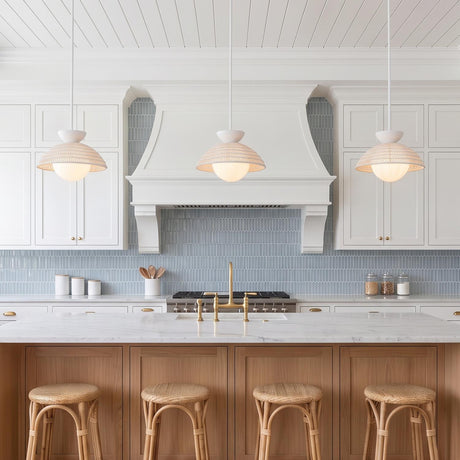 A coastal kitchen featuring three Santino Pendant Matte White and White Rattan fixtures over a marble island with light wood cabinets and blue picket tile backsplash.