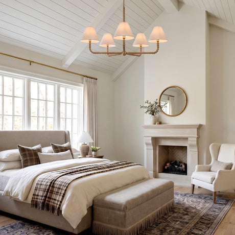 A modern farmhouse bedroom with a natural wood beaded chandelier hanging from a vaulted beamed ceiling above a beige upholstered bed and a stone fireplace.