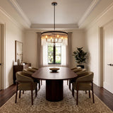 A contemporary dining room with the Marcella 4 Light Chandelier 24" Matte Black suspended over an oval walnut table and green chairs under a coffered ceiling.
