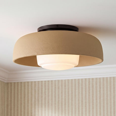 A transitional foyer with the Stratford Medium Flush Mount in aged iron and terracotta finishes mounted along the ceiling above tan striped wallpaper and white crown molding.