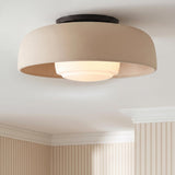 A transitional foyer featuring a Stratford Medium Flush Mount in aged iron and beige on a standard ceiling above beige striped wallpaper and white crown molding.