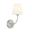 Estelle Wall Sconce 13", Brushed Nickel and Opal Glass, three-quarter view showing curved arm and lit tapered opal glass shade