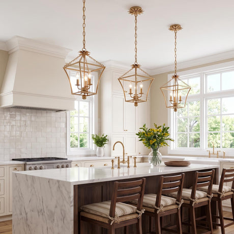 A traditional kitchen features three Alice Lantern Pendant 11", Antique Gold fixtures hanging over a white marble waterfall island with dark wood bar stools and white cabinetry.