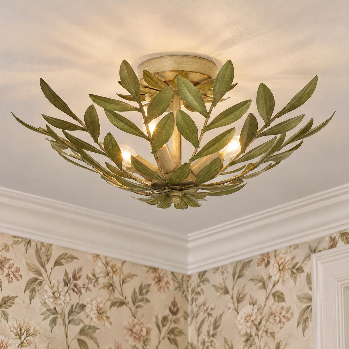 A traditional foyer with the Alison Semi-Flush 21", Antique Sage fixture featuring green leaf metalwork mounted on the ceiling near floral wallpaper and white crown molding.