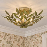 A traditional foyer with the Alison Semi-Flush 21", Antique Sage fixture featuring green leaf metalwork mounted on the ceiling near floral wallpaper and white crown molding.
