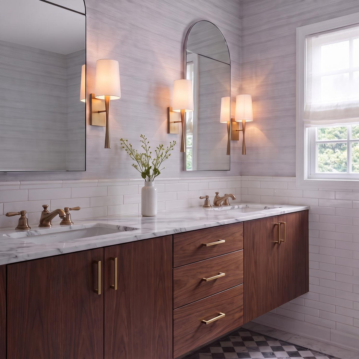 A transitional bathroom features the Kellan Wall Sconce 18", Aged Brass and White Fabric mounted beside arched mirrors above a walnut double vanity.