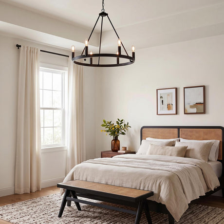 A transitional bedroom featuring a matte black Trenton 6 Light Chandelier hanging in the ceiling center above a bed with a woven cane headboard and neutral linens.