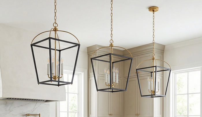 Three brass and black Langford metal open-frame lantern pendant lights hanging in a bright kitchen with cream cabinets and white walls.