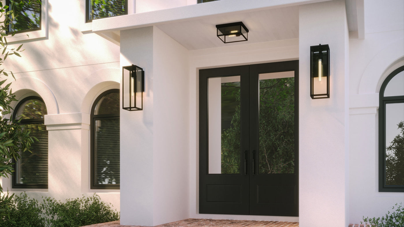 Sam Large 24" Wall Lights and 12" Flush Mount Ceiling Light are shown together on a white stucco home with black front doors and a brick porch. 